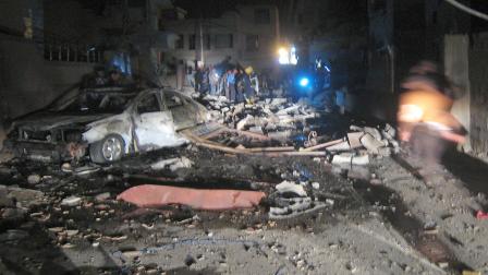 Security forces and civilians inspect the scene of a car bomb attack near a mosque in Kirkuk, 290 kilometers (180 miles) north of Baghdad, Iraq, Saturday, Aug. 10, 2013.