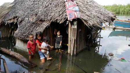Children emerge from their half-submerged home which was damaged by Tuesdays 7.2-magnitude earthquake in Cortes township, Bohol province in central Philippines Wednesday, Oct. 16, 2013.