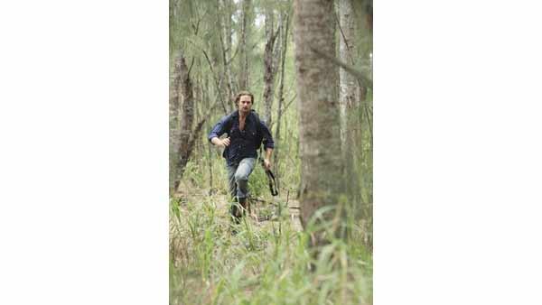Sawyer (Josh Holloway) runs through a forest.