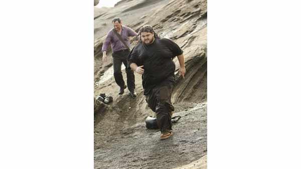 Ben Linus (Michael Emerson) and Hurley (Jorge Garcia) run down the rocks. They will later become guardians of the Island, and the best of friends.