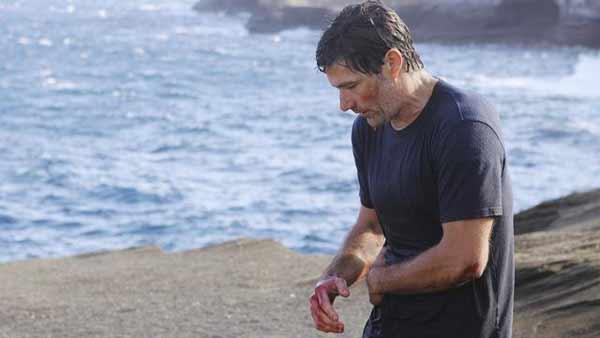 Jack Shepard (Matthew Fox) clutches his side. Earlier, he was stabbed by the Man in Black, who he then pushed over a cliff.