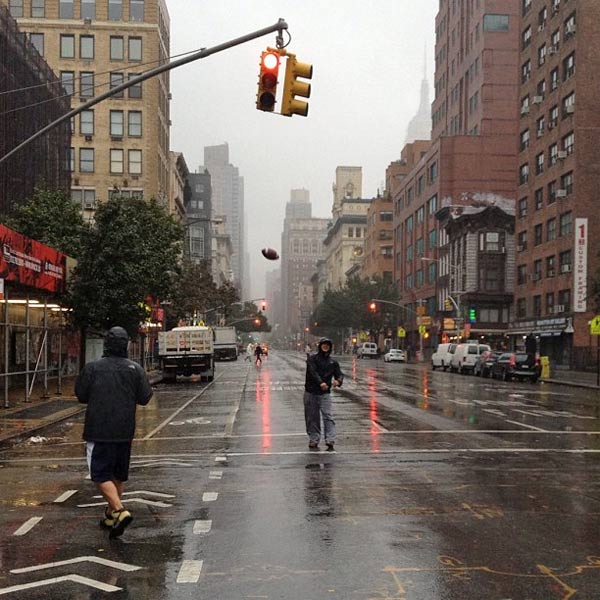 Two men play football in the street in New York...