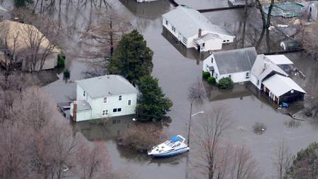 A power boat floats through a neighborhood in Warwick, R.I., Wednesday, March 31, 2010. Rhode Island rivers overflowed their banks, causing flooding and road closures after three days of record breaking rains.