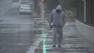 A man is seen walking in the rain in the Monrovia area on Monday, May 6, 2013.