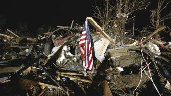 A flag flies in the debris of a mobile home after a tornado struck a mobile home park near Dale, Okla., Sunday, May 19, 2013.