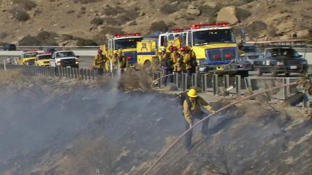 Firefighters are shown battling a brush fire along a hillside in this undated file photo.