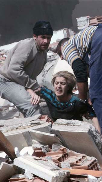 People rescue a woman trapped under debris after...