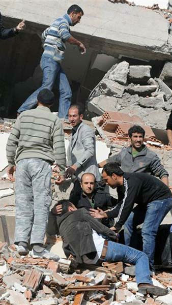 People try to save people trapped under debris...