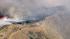 Smoke rises above the hills of Castaic, where a...