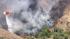 A helicopter makes a water drop on a brush fire...