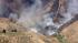 Smoke rises above the hills of Castaic, where a...