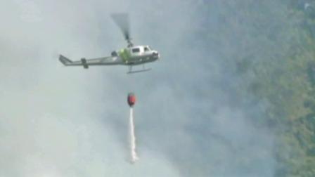 A helicopter aids firefighting efforts during the Robbers Fire, burning outside Sacramento.