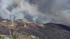 A plane approaches a brush fire burning in rural...