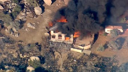 A home goes up in flames in as a brush fire raged in Aguanga, just east of Temecula, on Tuesday, Aug. 14, 2012. Several homes were evacuated and some structures were damaged.