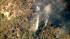 A helicopter makes a water drop over a wildfire...