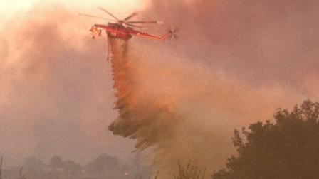 A helicopter makes a drop over a fire in Murrieta on Sunday, Sept. 23, 2012.