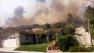 Smoke from a massive brush fire is seen behind a home in Camarillo Springs on Thursday, May 2, 2013.