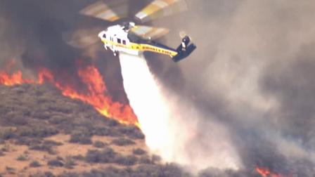 A helicopter aids in the firefight after a brush fire broke out in the Castaic area on Friday, May 17, 2013.