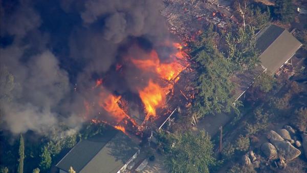 A structure goes up in flames as a wildfire burns south of Banning near Highway 243 on Wednesday, August 7, 2013.