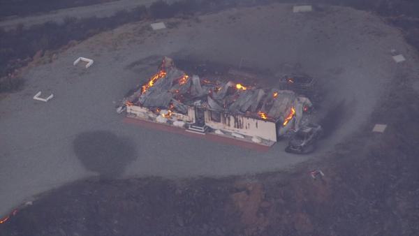 A structure goes up in flames as a wildfire burns south of Banning near Highway 243 on Wednesday, August 7, 2013.