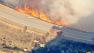 Flames shoot up along a road in the Santa Clarita area on Friday, Aug. 9, 2013.