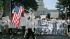 Mai Moua-Thor carries an U.S. flag as she and...