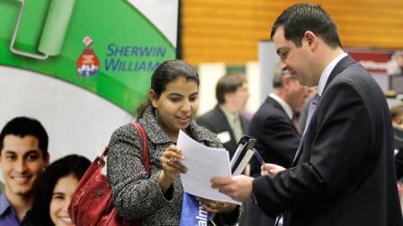 Heba Mostafa hands her resume to Sean Martin, a representative of Buckeye International, at the 32nd Annual Spring Career Fair at Cleveland State University.