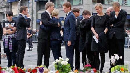 Members of the public stand near flower tributes as they grieve following a mass for sorrow and hope held in Oslo Cathedral Sunday July 24, 2011