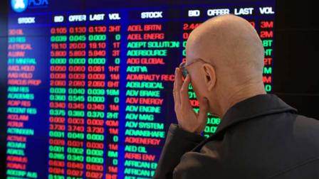 Rudolf Oultz watches the display board at the Australia Stock Exchange in Sydney, Monday, Aug. 8, 2011. Australian and New Zealand markets have opened lower in reaction to ratings agency