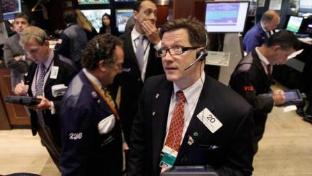 Trader Christopher Forbes foreground right, watches prices as he works on the floor of the New York Stock Exchange Thursday, Aug. 18, 2011.