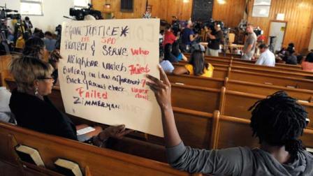 Myranette Boynton, left, and Jamala Mitchell hold a sign during an open forum on police misconduct, sponsored by the NAACP, in Sanford, Fla., Wednesday, March 21, 2012.