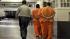 In this Aug. 3, 2006 file photo, a correctional officer escorts a group of recently arrived inmates through the Deuel Vocational Institution in Tracy, Calif. Prison