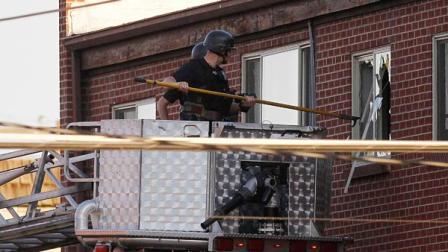 Police break out a window of an apartment where the suspect in a shooting at a movie theatre lived in Aurora, Colo., Friday, July 20, 2012.