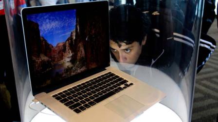 An attendee looks at the new MacBook Pro on display at the Apple Developers Conference in San Francisco, Monday, June 11, 2012.