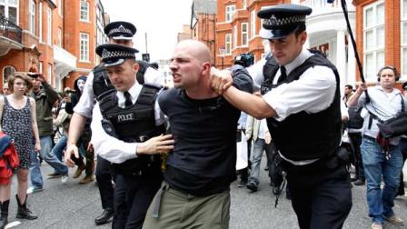 British police officers arrest a protesters in support of WikiLeaks founder Julian Assange from the front of Ecuadorian Embassy in central London, London, Thursday, Aug. 16, 2012.