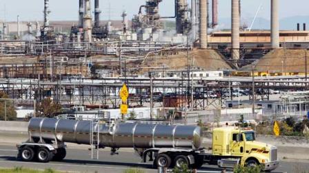 a tanker truck passing the Chevron oil refinery in Richmond, Calif