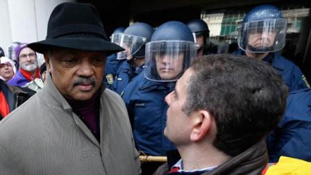 Rev. Jesse Jackson, left, and Lansing Mayor Virg Bernero, right, try to enter past Michigan State Police at the George W. Romney State Building, where Gov. Snyder has an office in Lansing, Mich., Tuesday, Dec. 11, 2012.