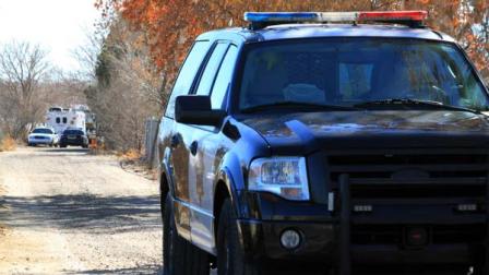 A Bernalillo County sheriffs deputy blocks the dirt road that leads to a home where detectives on Sunday, Jan. 20, 2013