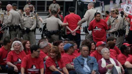 Las Vegas Metropolitan Police officers lead away a protestors during a civil disobedience demonstration by Culinary Union workers outside the Cosmopolitan Hotel-Casino