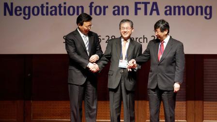 South Korean chief negotiator Choi Kyong-lim, center, his Japanese counterpart Koji Tsuruoka, right, and Chinese counterpart Yu Jianhua, left, hold hands each other at a photo call before their talks in Seoul, South Korea