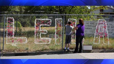 Teacher Cecilia Richardson helps a student tie a ribbon honoring murder victim, first grader Lelia Fowler