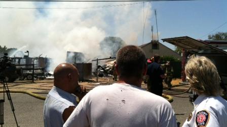 Resident talking to @Local753 while firefighters douse the flames at his house.