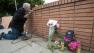 A makeshift memorial is next to Akiva Sherman, 62, as he repairs the wall.