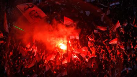Opponents of Egypts Islamist President Mohammed Morsi celebrate as they light flares and wave national flags and his picture with Arabic reads, leave, in Tahrir Square