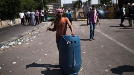 A supporter of ousted Egyptian President Mohammed Morsi stands on guard armed with a stick and a shield during a protest at Cairo University, Giza, Egypt, Friday, July 5, 2013.