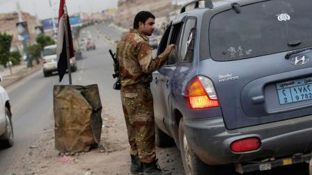 A Yemeni soldier inspects a car at a checkpoint on a street leading to the U.S. embassy in Sanaa, Yemen