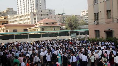 People rush out their apartments and offices after they felt a major earthquake that struck Baluchistan province in southwest Pakistan, 693 Kilometers (430 miles) from Karachi, Pakistan, Tuesday, Sept. 24, 2013.
