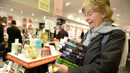 Monica Nordberg collects an armful of books by newly announced 2013 Nobel literature prizewinner, Alice Munro of Canada, at a Stockholm bookstore Thursday Oct. 10, 2013. Customers waited for the prize announcement to be first in line.