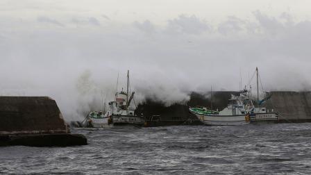 Big waves go over breakwater near anchored fishing boats in Fujisawa, near Tokyo, Monday, Sept. 16, 2013.