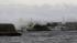 Big waves go over breakwater near anchored fishing boats in Fujisawa, near Tokyo, Monday, Sept. 16, 2013.